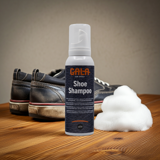 CasaBellissimo GALA for Shoes gebrauchsfertiges Schuh - Shampoo in der Spender -Sprühdose 125 ml auf einem Holztisch und im Hintergrund ein paar schmutzige Sportschuhe und ein kleiner Berg weißer Schaum