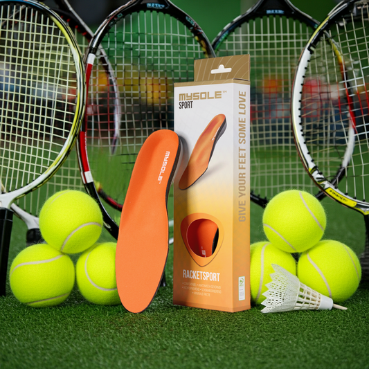 Die CasaBellissimo MYSOLE Sport Racketsport hochwertige Einlegesohle mit Verpackung für Tennis, Badminton, Squash etx. auf grünem Kunstrasen mit Tennisbällen und verschiedenen Schlägern  Rackets