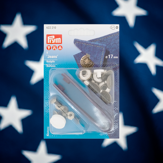 Prym Jeansknöpfe "American Star", nähfrei, Ø 17 mm in altsilber und mit Werkzeug in der Blister Verpackung im Hintergrund weiße Sterne auf dunkelblauem Grund