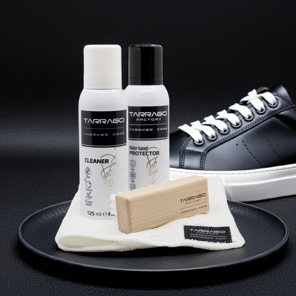 Tarrago Sneakers Care Schuhpflege-Set 4-teilig mit Cleaner Reinigungsmittel und Protector, ein natürliches Imprägnierspray, jeweils in der eleganten schwarz weißen Verpackung mit dazu passendem Poliertuch und einer Holzschuhbürste  auf einem schwarzen runden Tablett mit einem schwarz weißen Sneaker auf schwarzem Hintergrund