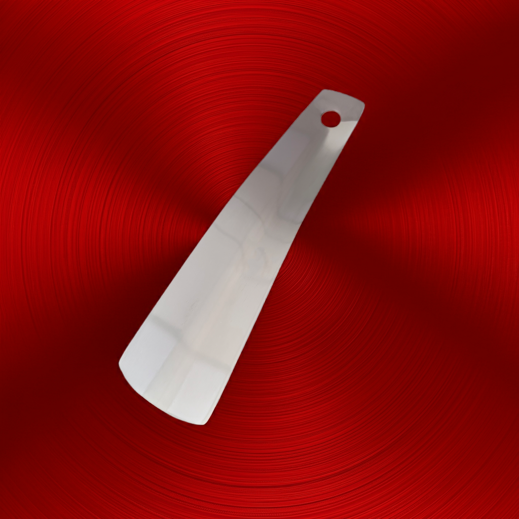 Mini-Schuhanzieher aus Metall auf rotem Hintergrund